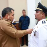 Pj Bupati Aceh Besar, Muhammad Iswanto, menyematkan PIN secara simbolis kepada Muhammad Basir, S.STP, M.Si sebagai Camat Darul Imarah saat pelantikan di Aula Meuligoe Bupati Aceh Besar, Kota Jantho, Senin, (8/5/2023). FOTO/ HO habanusantara.net
