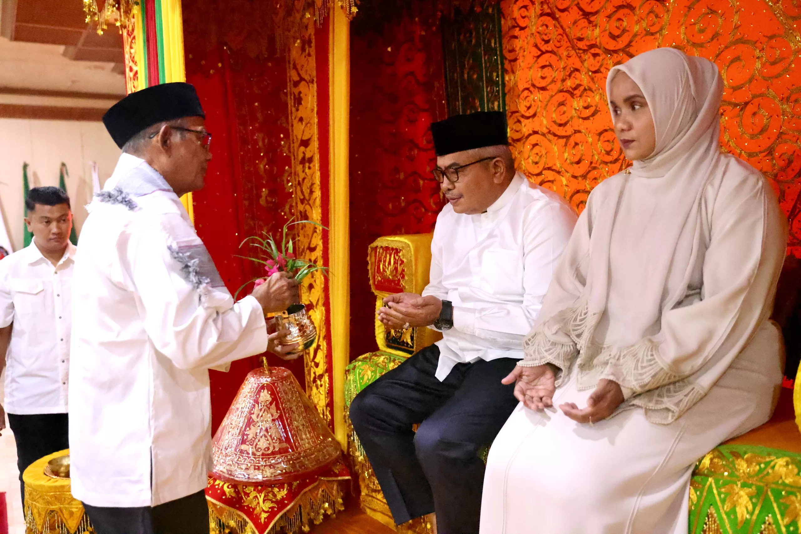 Penjabat Gubernur Aceh, Bustami dan istri Mellani Subarni mengikuti prosesi peusijuek yang dilakukan oleh imam besar Masjid Raya Baiturrahman Tgk.H. Azman Ismail, dalam acara penyambutan dan buka puasa bersama Kepala SKPA dan ASN Pemerintah Aceh, di Kantor Gubernur Aceh, Kamis, (14/3/2024).
