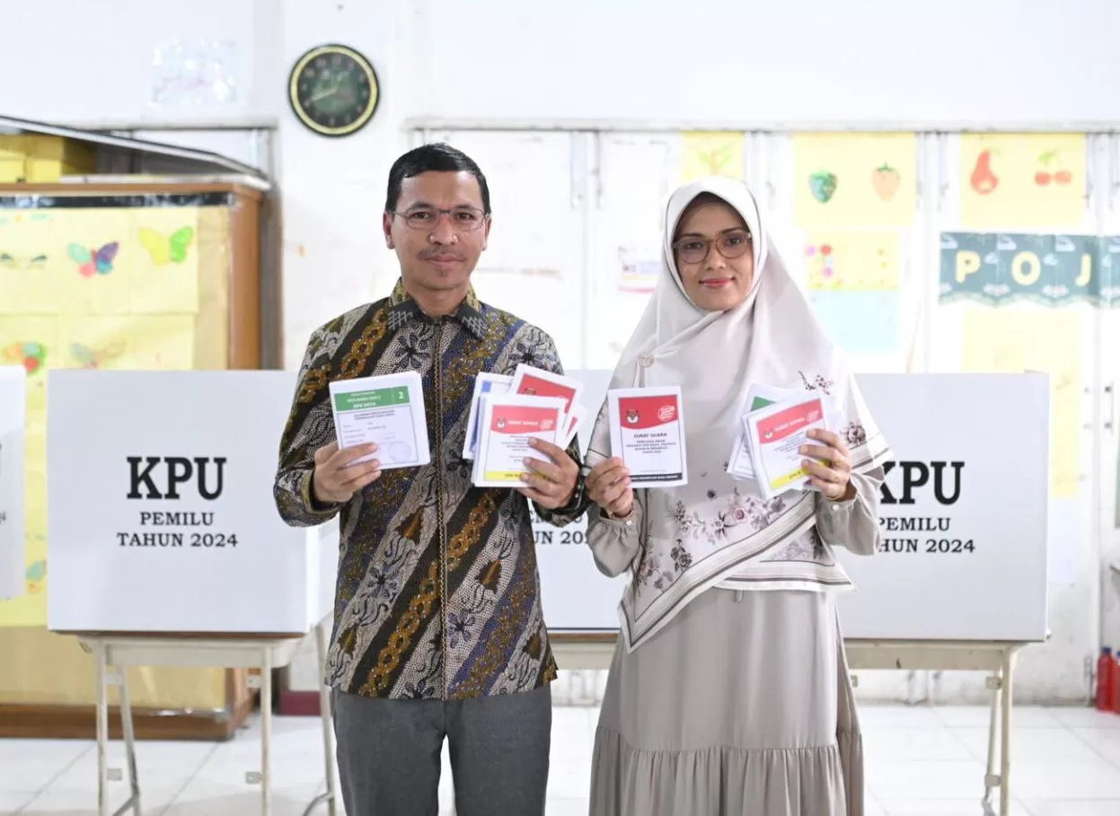 Ketua DPRK Banda Aceh, Farid Nyak Umar, bersama istri, Santi Zuhra, memberikan hak suaranya dalam Pemilu 2024 di TPS 11 Gampong Beurawe, Kecamatan Kuta Alam, Banda Aceh, Rabu (14/2/2024). FOTO/ HUMAS DPRK BANDA ACEH