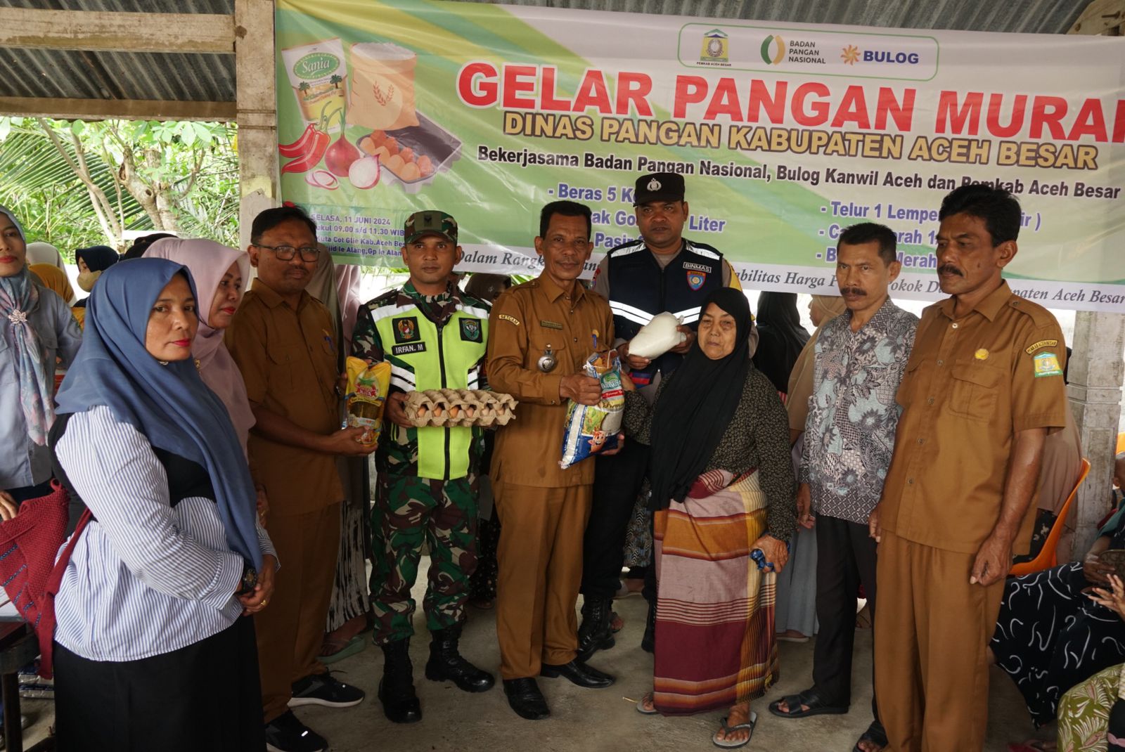 Camat Kuta Cot Glie Zulkifli S.Sos menyerahkan paket sembako secara simbolis pada pangan murah Pemkab Aceh Besar di Gampong Ie Alang, Kecamatn Kuta Cot Glie, Aceh Besar, Selasa (11/6/2024). FOTO/MC ACEH BESAR