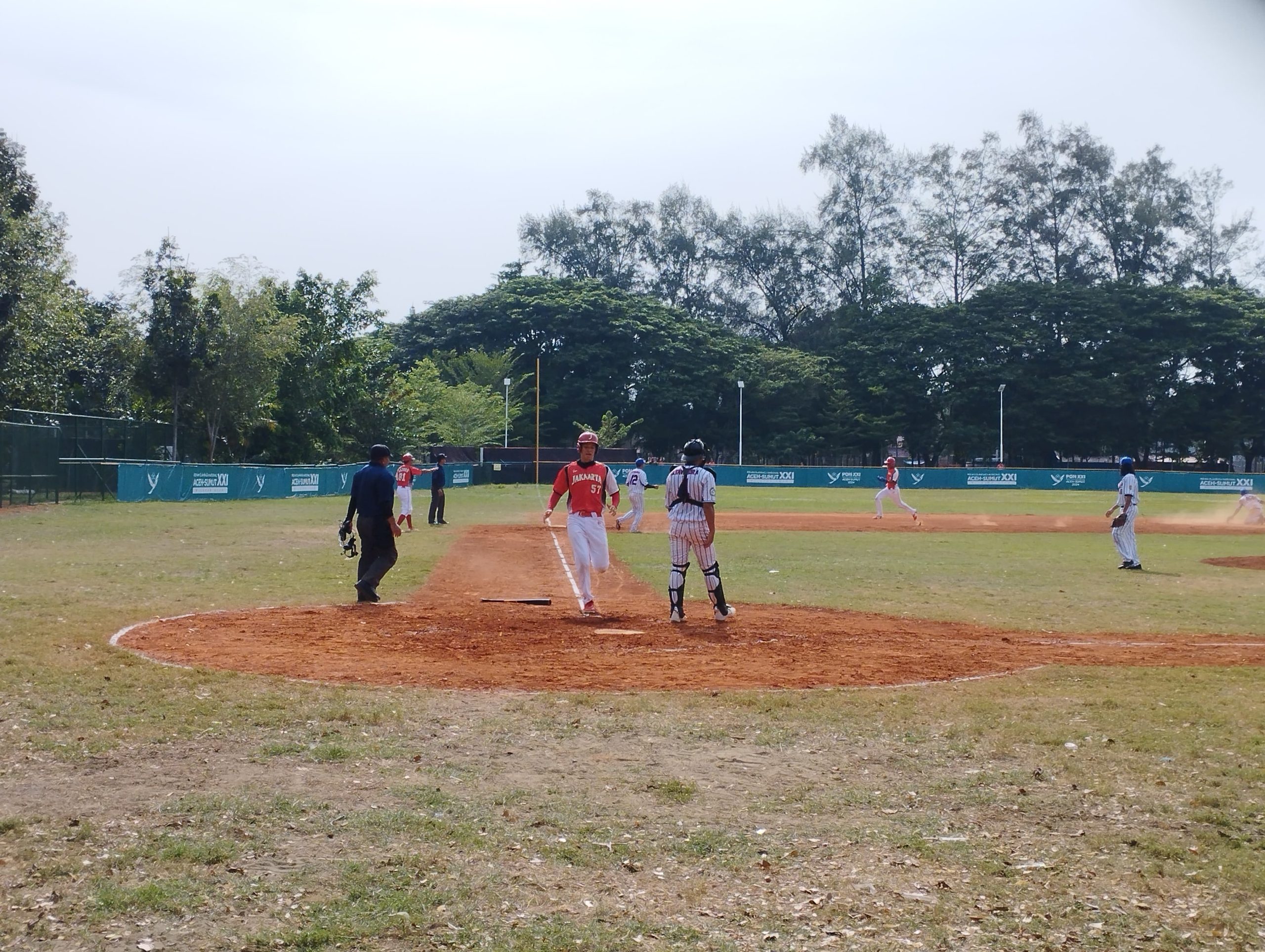 Pemain DKI Jakarta, Alexander R Aribowo mencetak poin usai berhasil kembali ke home base saat bertanding dengan tim Lampung pada babak super round baseball di Lapangan Tugu Darussalam Banda Aceh, Rabu (11/9/2024)