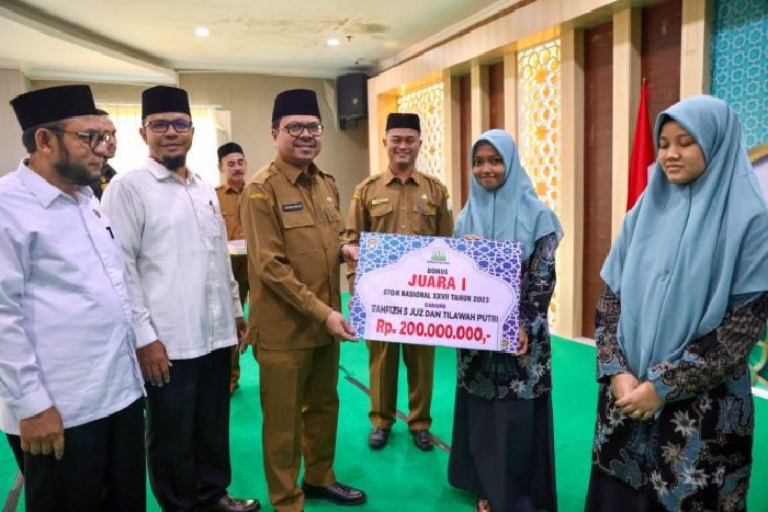Penjabat Sekretaris Daerah Aceh, Azwardi AP MSi mewakili PJ Gubernur Aceh menyerahkan bonus juara STQH Nasional Ke-XXVII Tahun 2023, di Aula Kantor Dinas Syariat Islam Aceh, Senin (29/4/2024).