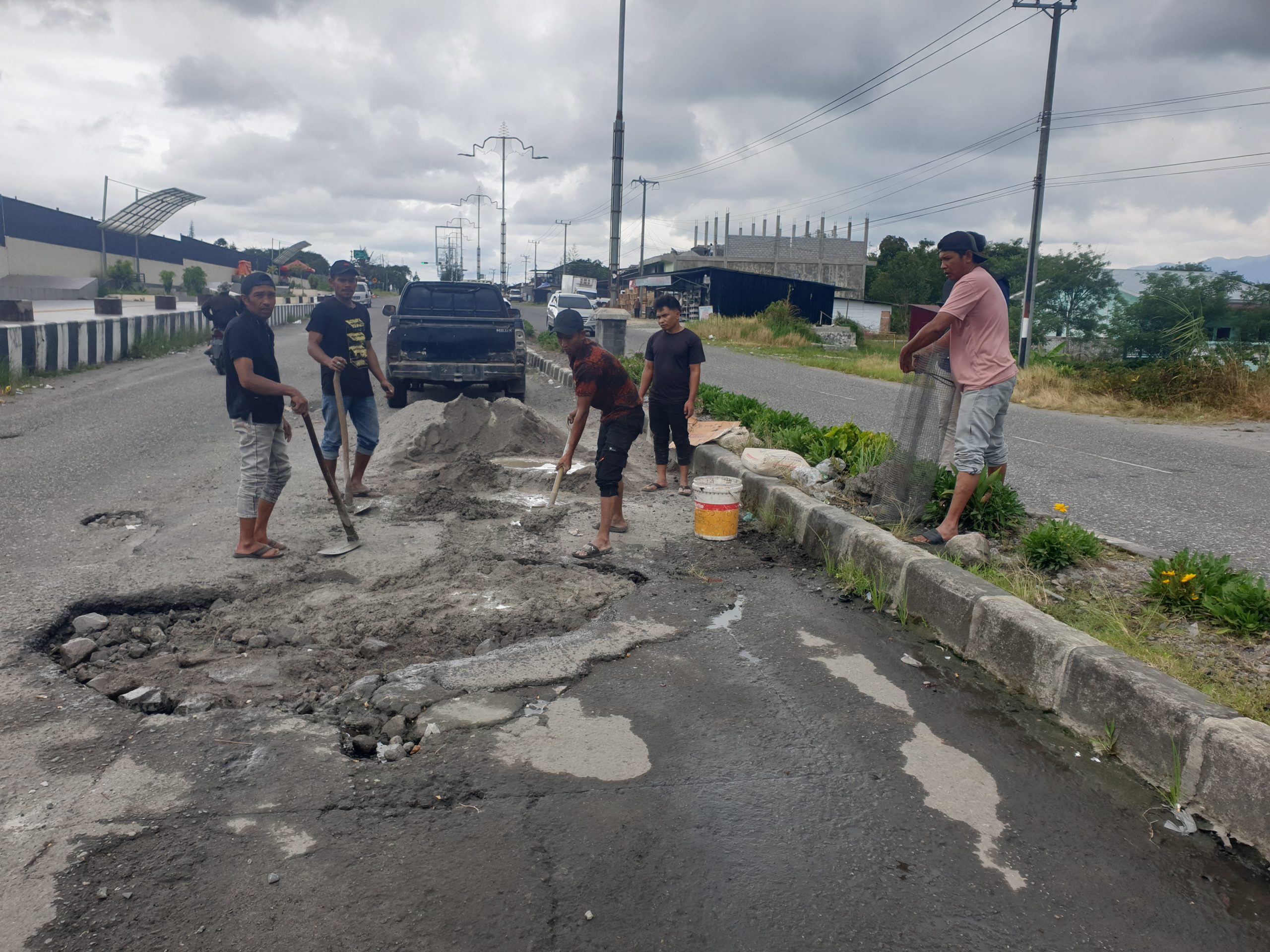sejumlah warga lakukan penambalan jalan berlubang di area Pendestrian (dok Gona).