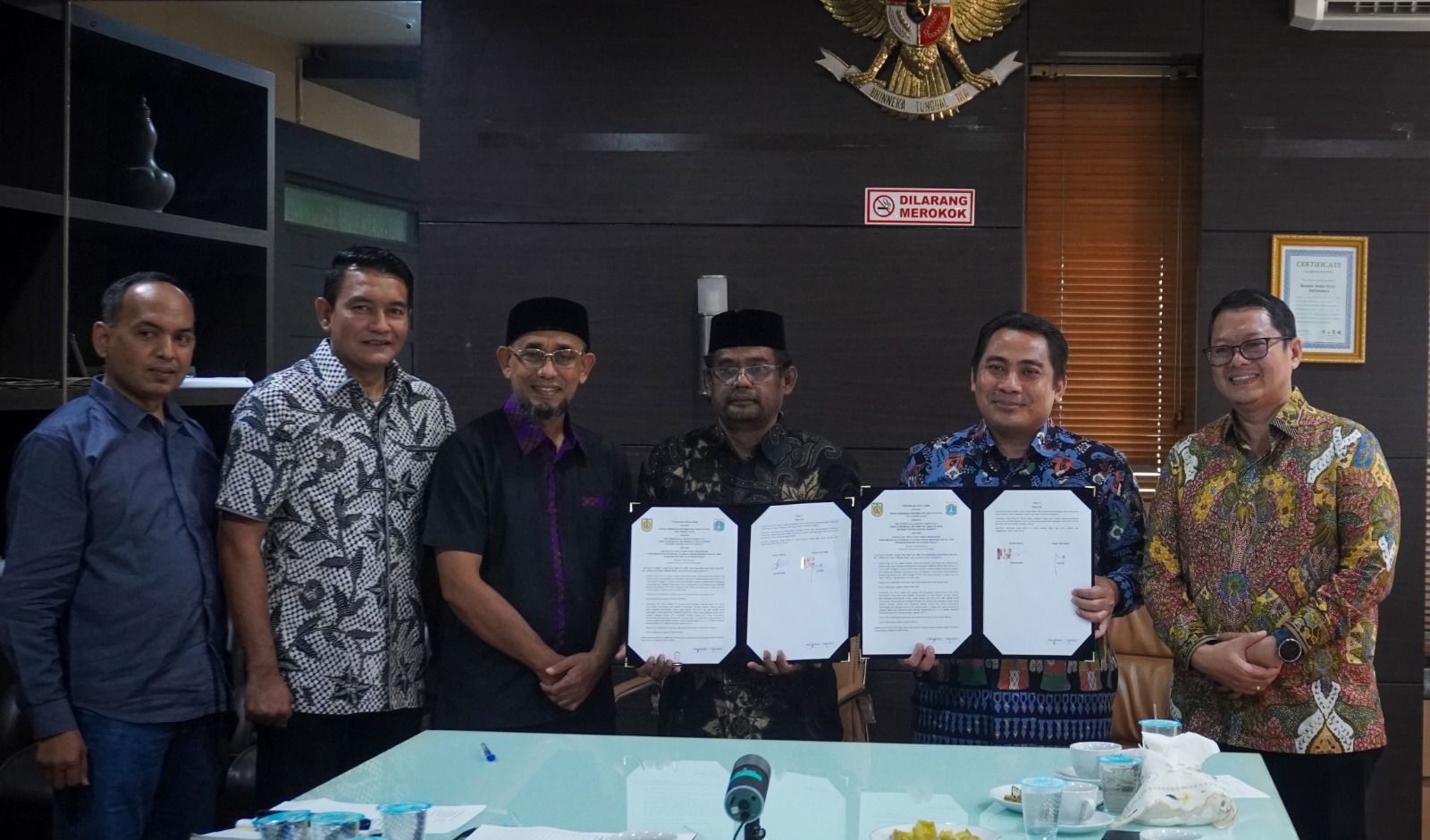 Pj Sekdako Jalaluddin bersama Kepala Dinas Komunikasi Informatika dan Statistik Kota Banda Aceh, Alizar dengan Plt Kepala Unit Pengelola Jakarta Smart City, Dinas Komunikasi Informatika dan Statistik Provinsi DKI Jakarta, Koharudin memperlihatkan dokumen kerja sama engembangan Integrasi Layanan Publik Berbasis Digital dan Branding Sistem Pelayanan Publik. di di Ruang Rapat Sekda Kota Banda Aceh, Sabtu (24/05/2025).