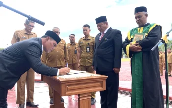 Sekda Aceh Besar, Bahrul Jamil, menandatangani berita acara pelantikan usai prosesi pengambilan sumpah jabatan di Kota Jantho, Senin (14/7/2025).