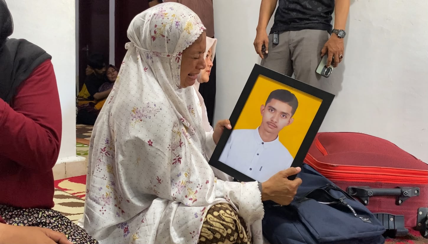 Nur Laila (47), melihat foto almarhum anaknya Muhammad Rasya Fadilla (18), mahasiswa yang meninggal setelah 22 hari menjalani pendidikan di asrama Poltekpel Malahayati Aceh. Foto: (Bithe)