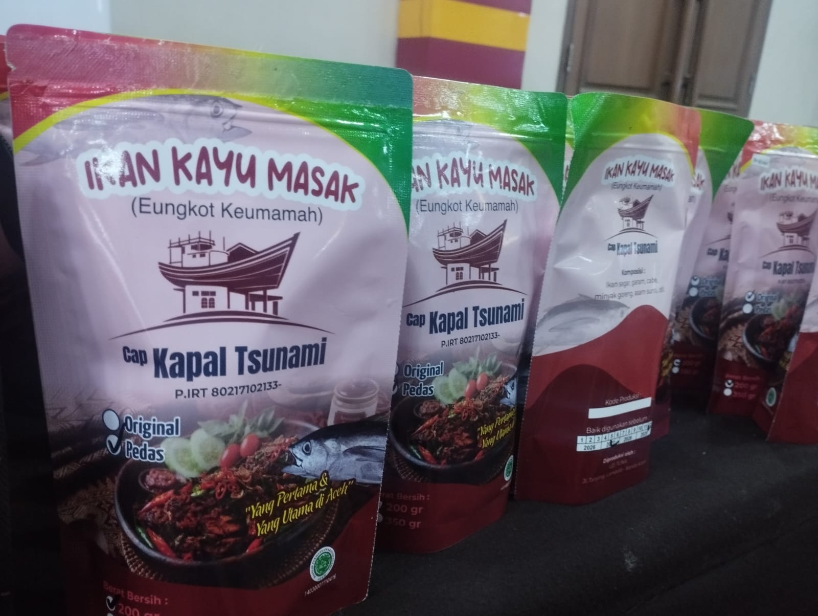 Usaha rumahan ikan kayu masak di kawasan Lampulo, Banda Aceh, memanfaatkan Instagram dan WhatsApp untuk memasarkan eungkot keumamah, salah satu olahan ikan khas Aceh. Melalui kedua platform tersebut, produknya menjangkau konsumen di Banda Aceh, Sabang, Lhokseumawe, Medan, hingga Jakarta. Pemanfaatan media digital membantu pelaku usaha memperluas pemasaran produk olahan hasil laut ke luar daerah. [Foto/HabaNusantar.net/Ismail]